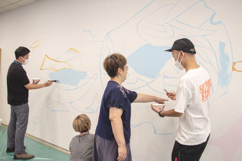 描き始めると柔和な雰囲気になる社員とアーティスト