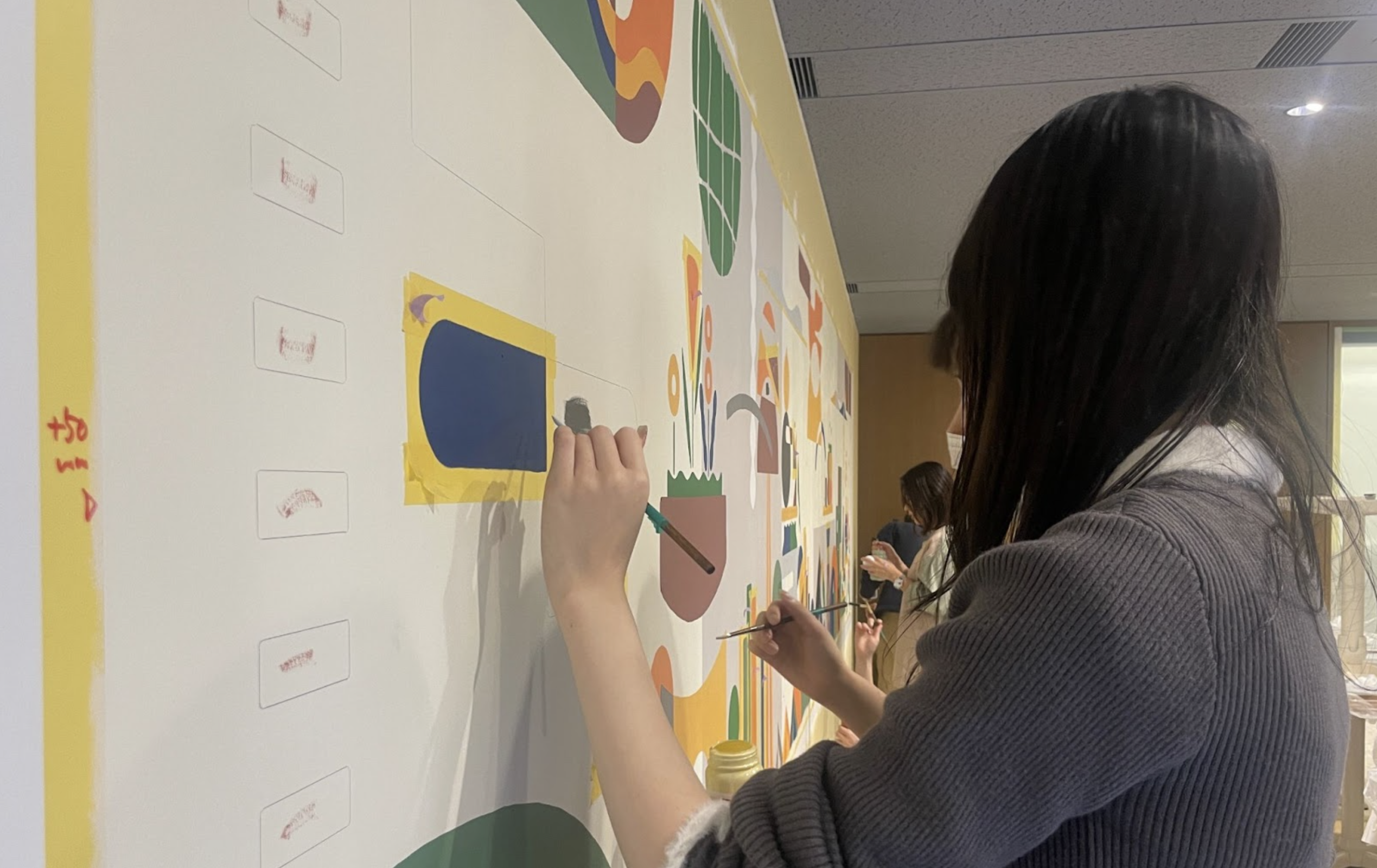 壁画のお手伝いをする会社員